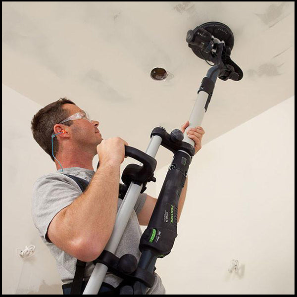 A man using the Festool planex drywall sander in a residential area, available at Clement's Paint in Austin, TX.